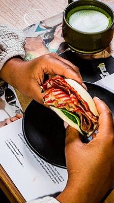 pair of hands holding a bao bun